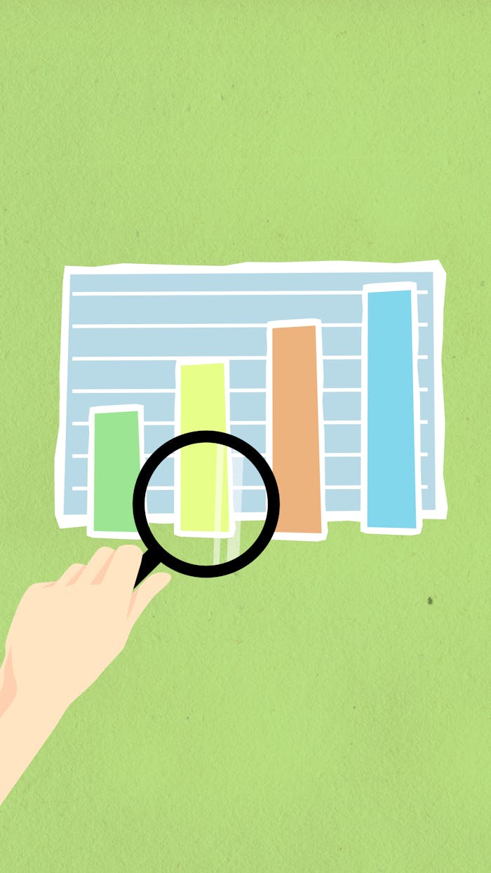 hero-img-01 Top view of decorative cardboard illustration of hand with magnifying glass above diagram with columns on green background